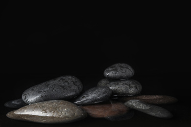 Photo of Stones in water on black background, space for text. Zen lifestyle