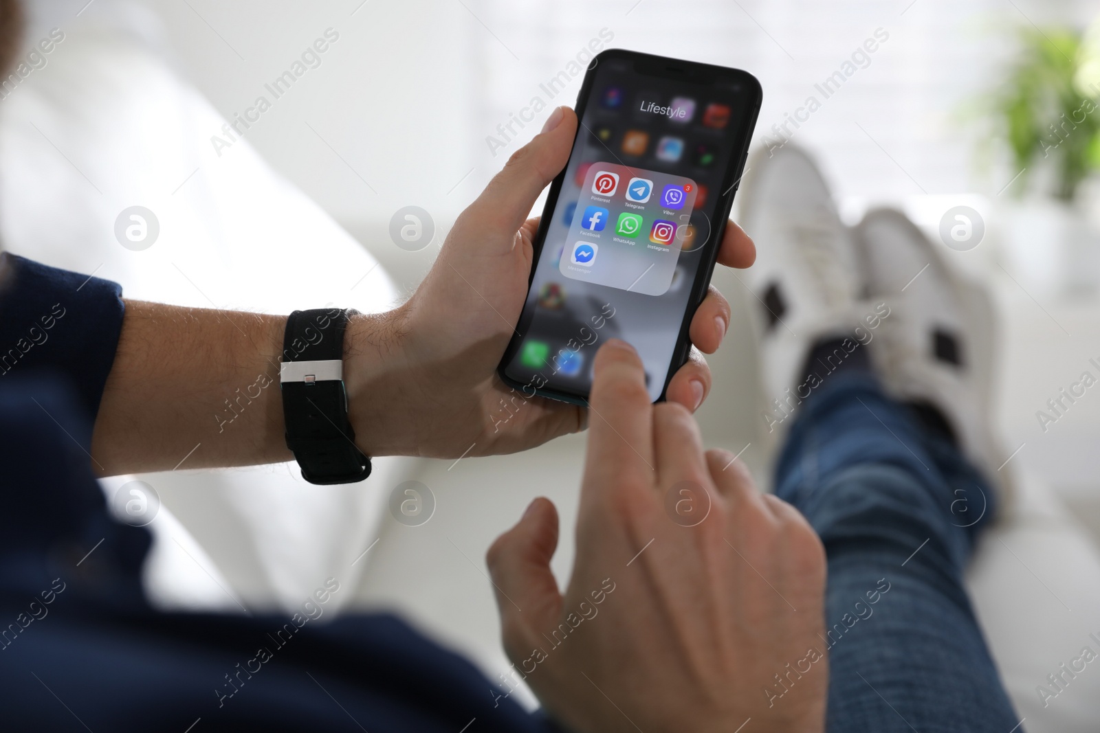 Photo of MYKOLAIV, UKRAINE - MARCH 16, 2020: Man holding iPhone 11 with social media icons on screen indoors, closeup