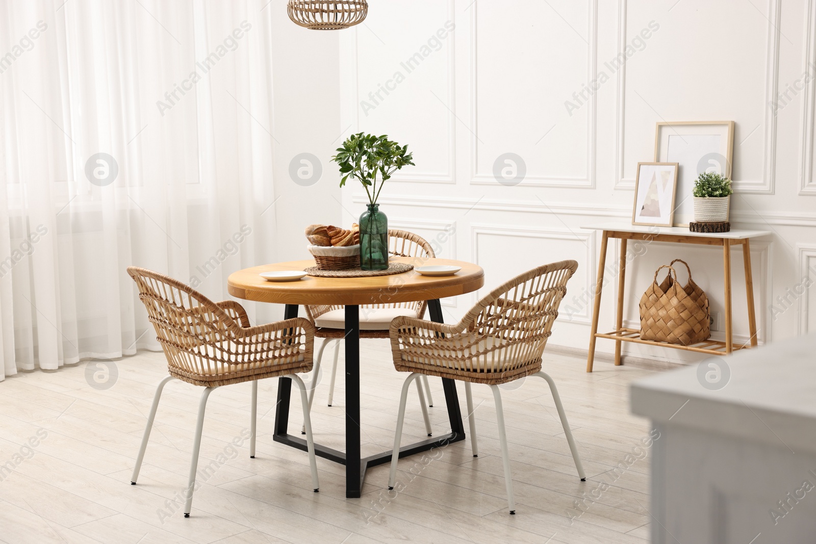 Photo of Dining room interior with comfortable furniture and green branches