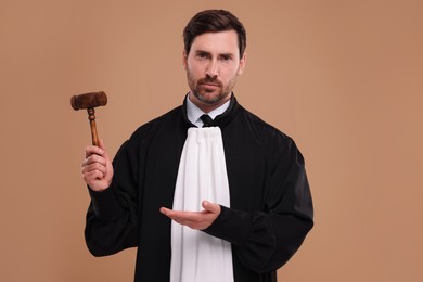 Photo of Judge showing gavel on light brown background