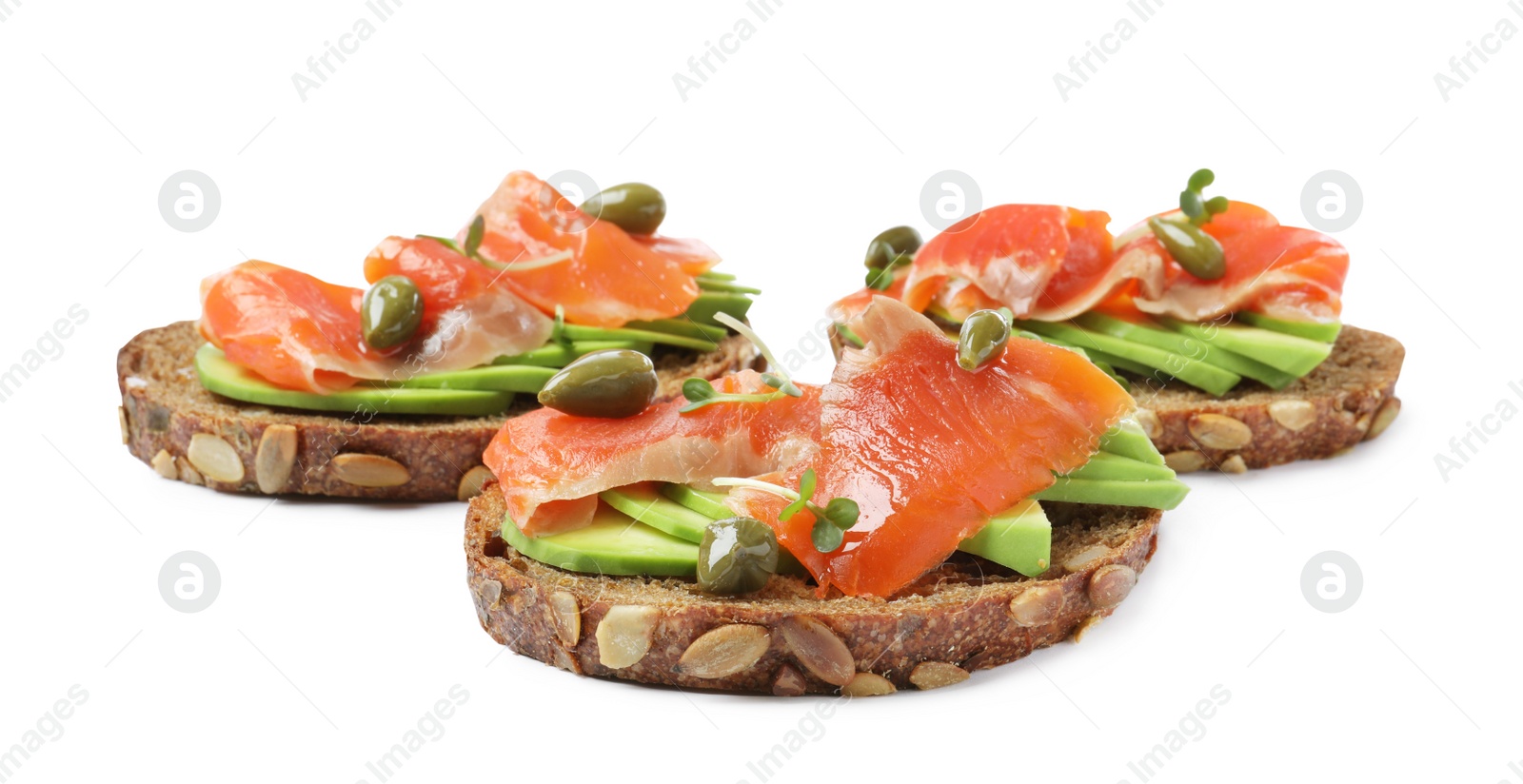 Photo of Delicious sandwiches with salmon, avocado and capers on white background