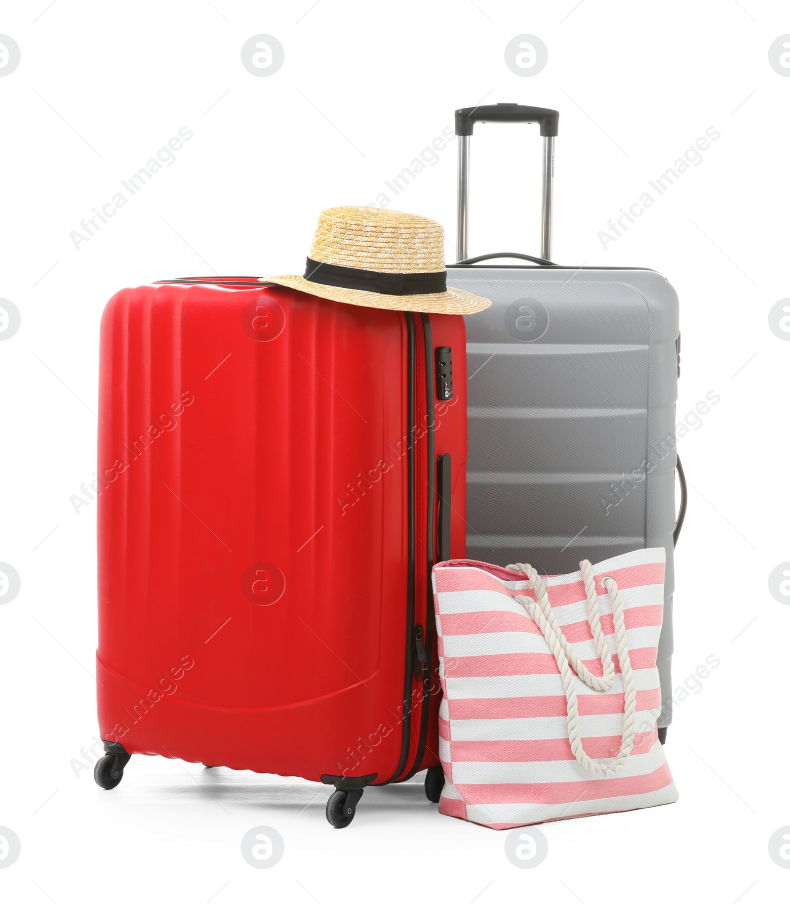 Photo of Packed suitcase with hat and hand-luggage on white background