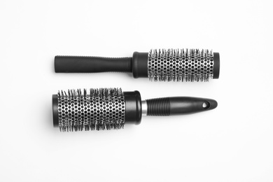 Photo of Modern round hair brushes on white background, top view