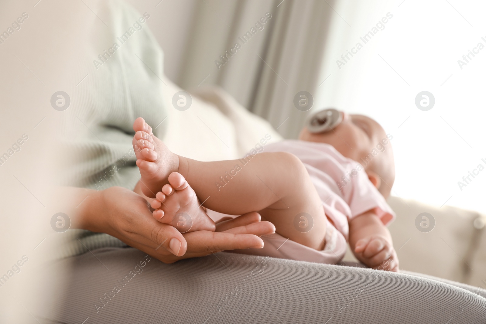 Photo of Mother holding her cute sleeping baby at home, closeup