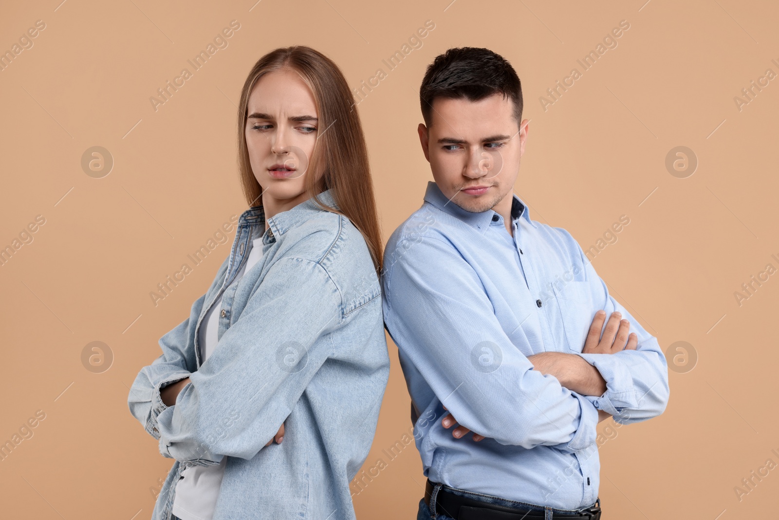 Photo of Portrait of resentful couple with crossed arms on beige background
