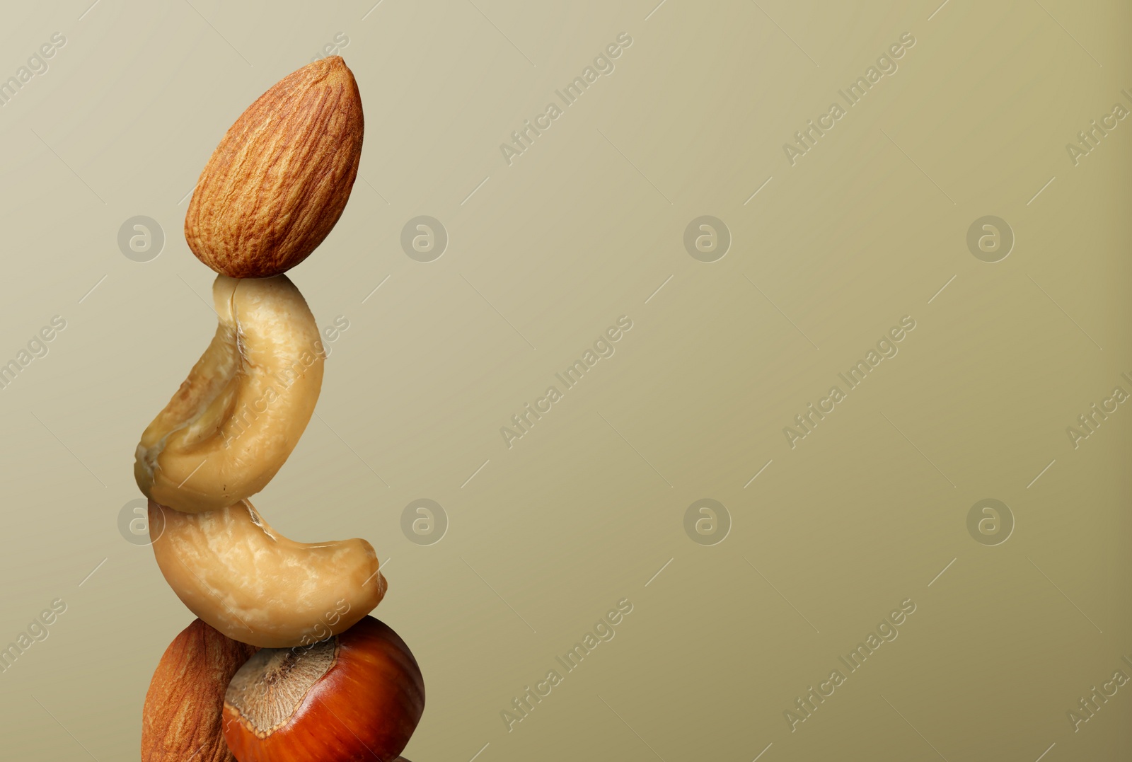 Image of Stacked different nuts on light brown gradient background, space for text