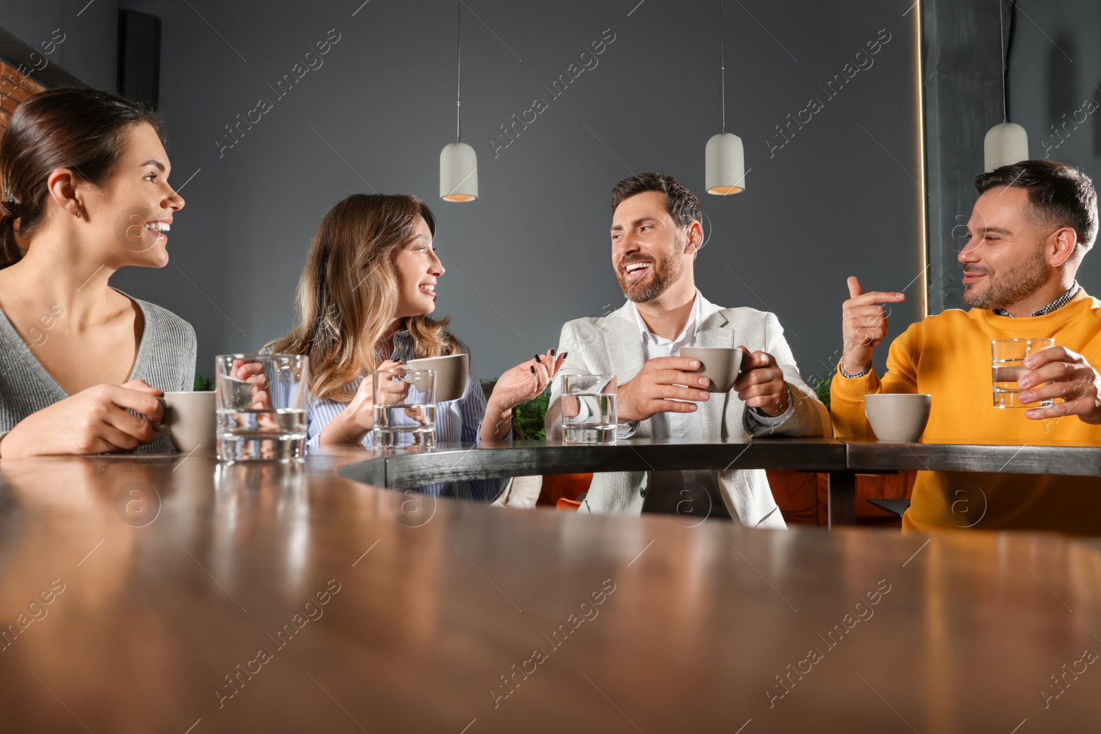 Photo of Friends with drinks spending time together in cafe