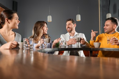 Photo of Friends with drinks spending time together in cafe