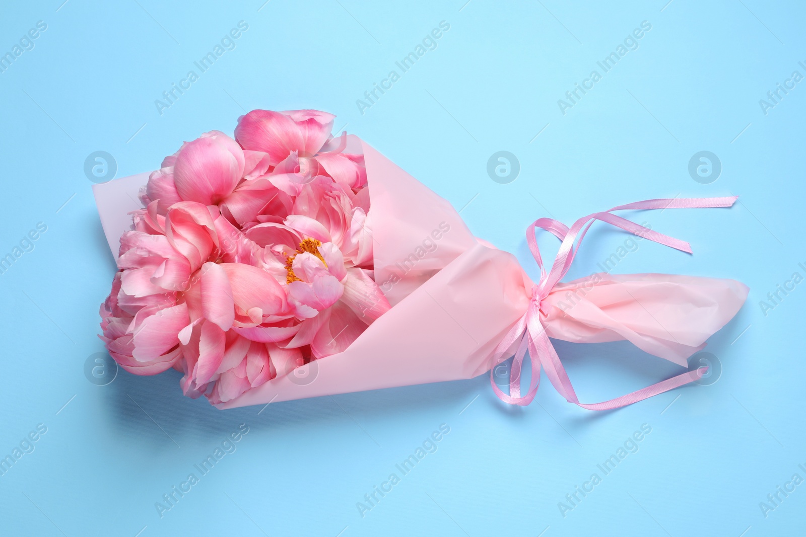 Photo of Beautiful bouquet of pink peonies on light turquoise background, top view