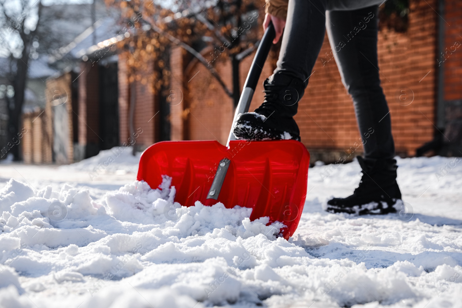 Photo of Person shoveling snow outdoors on winter day, closeup