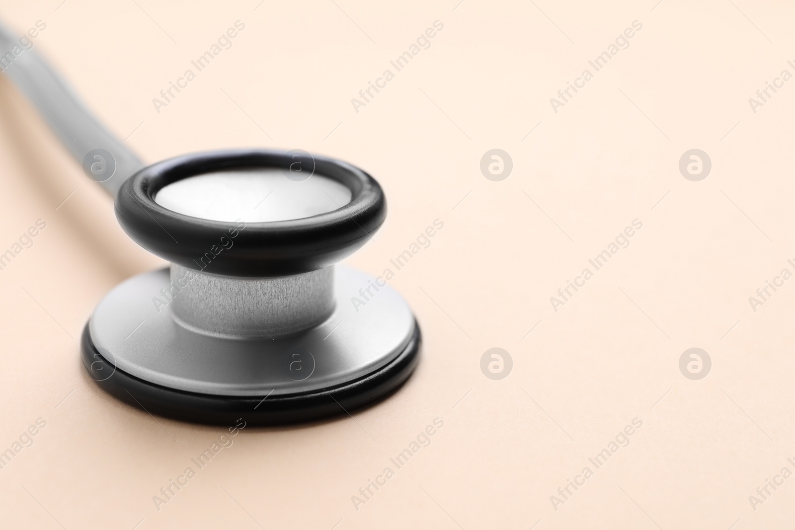 Photo of Stethoscope on beige background, closeup. Space for text