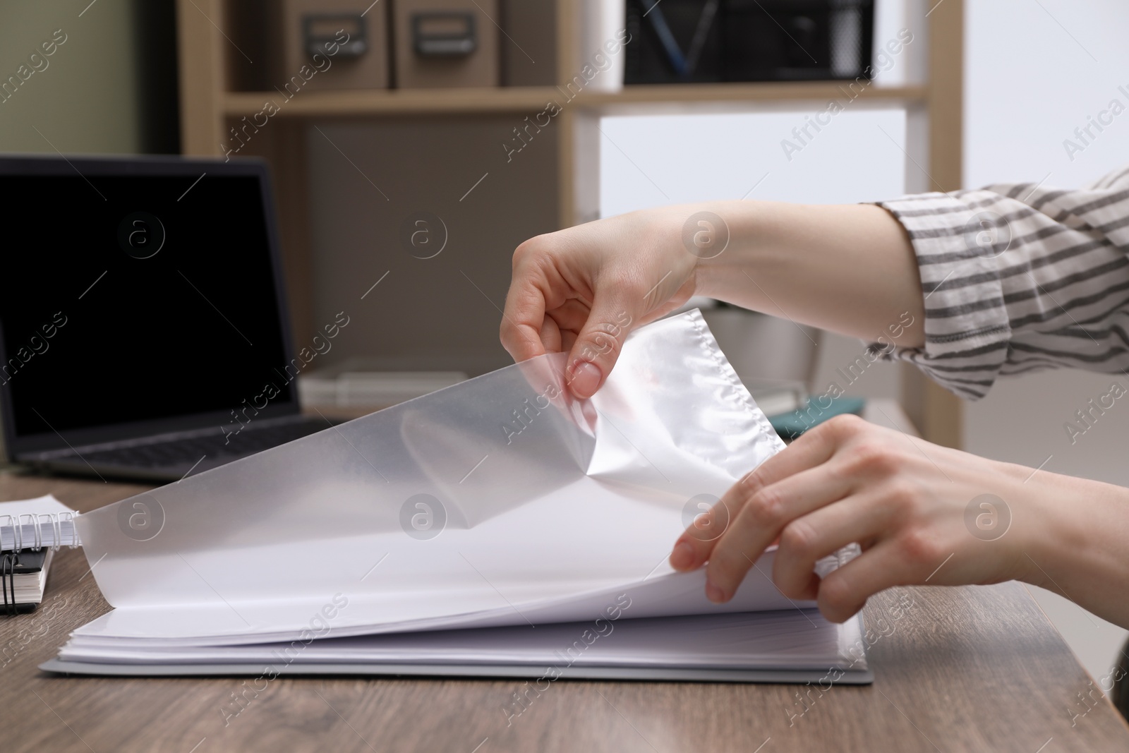 Photo of Woman with punched pockets at wooden table, closeup