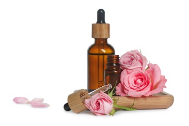 Photo of Bottles of essential rose oil and flowers on white background