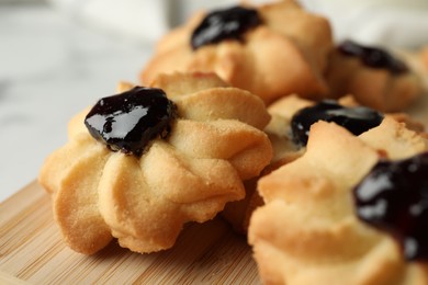Photo of Tasty shortbread cookies with jam on table, closeup