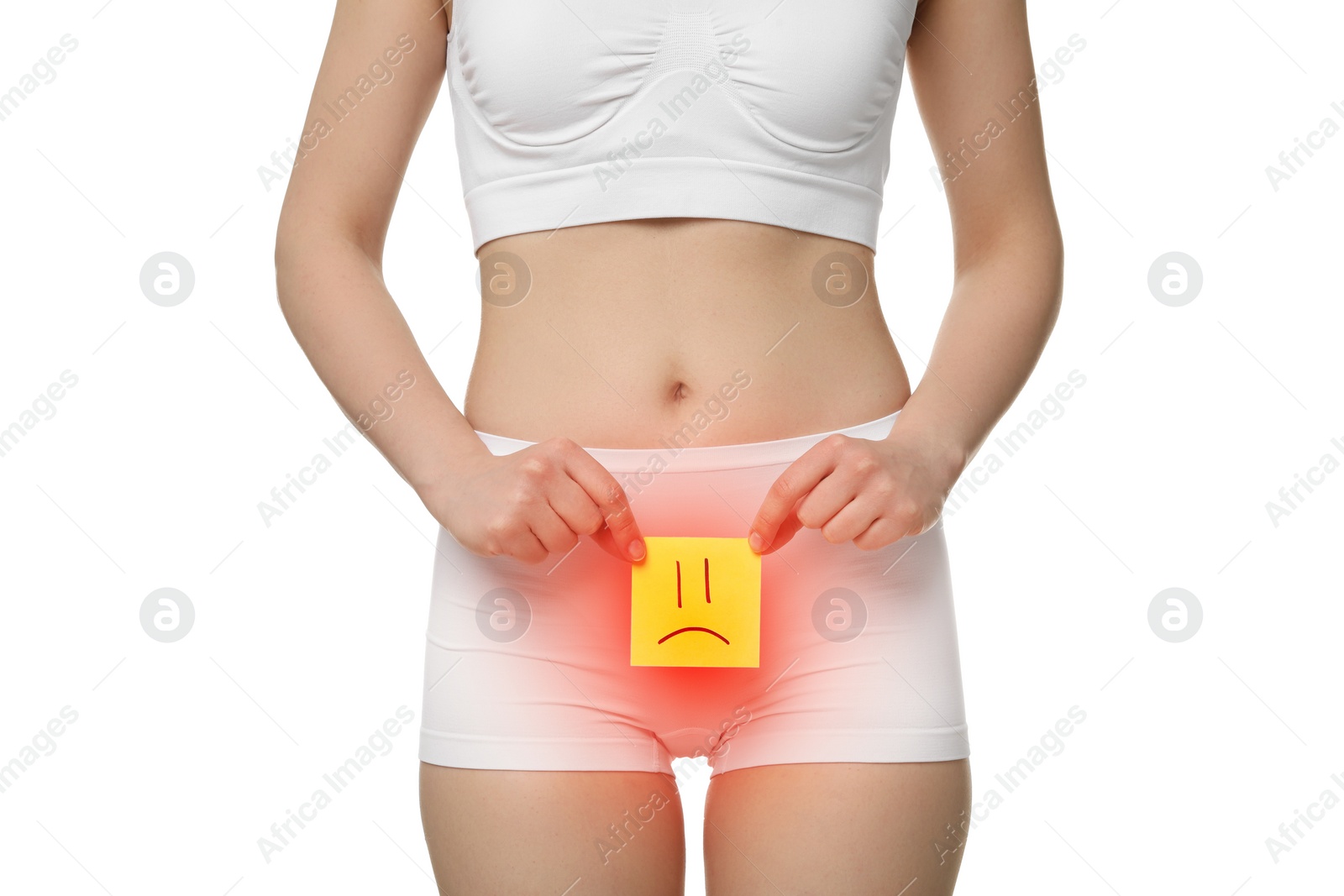 Image of Woman holding sticky note with drawn sad face and suffering from cystitis symptoms on white background, closeup