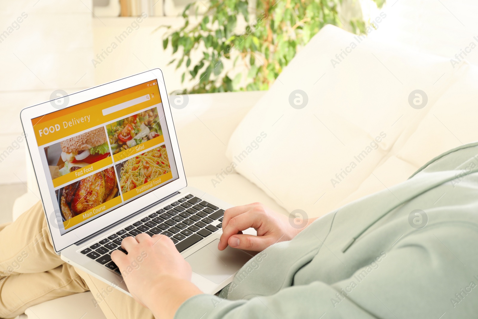 Photo of Man using laptop for ordering food online at home, closeup. Delivery service