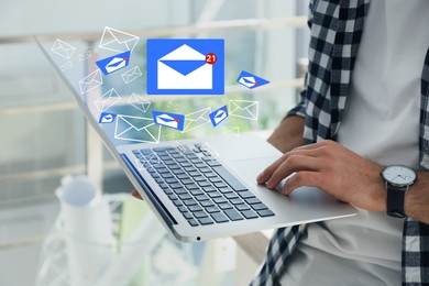 Man sending emails via laptop at home, closeup