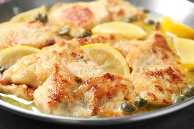 Photo of Delicious chicken piccata with lemons in pot, closeup