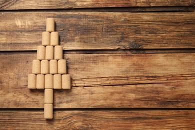 Photo of Christmas tree made of wine corks on wooden table, top view. Space for text