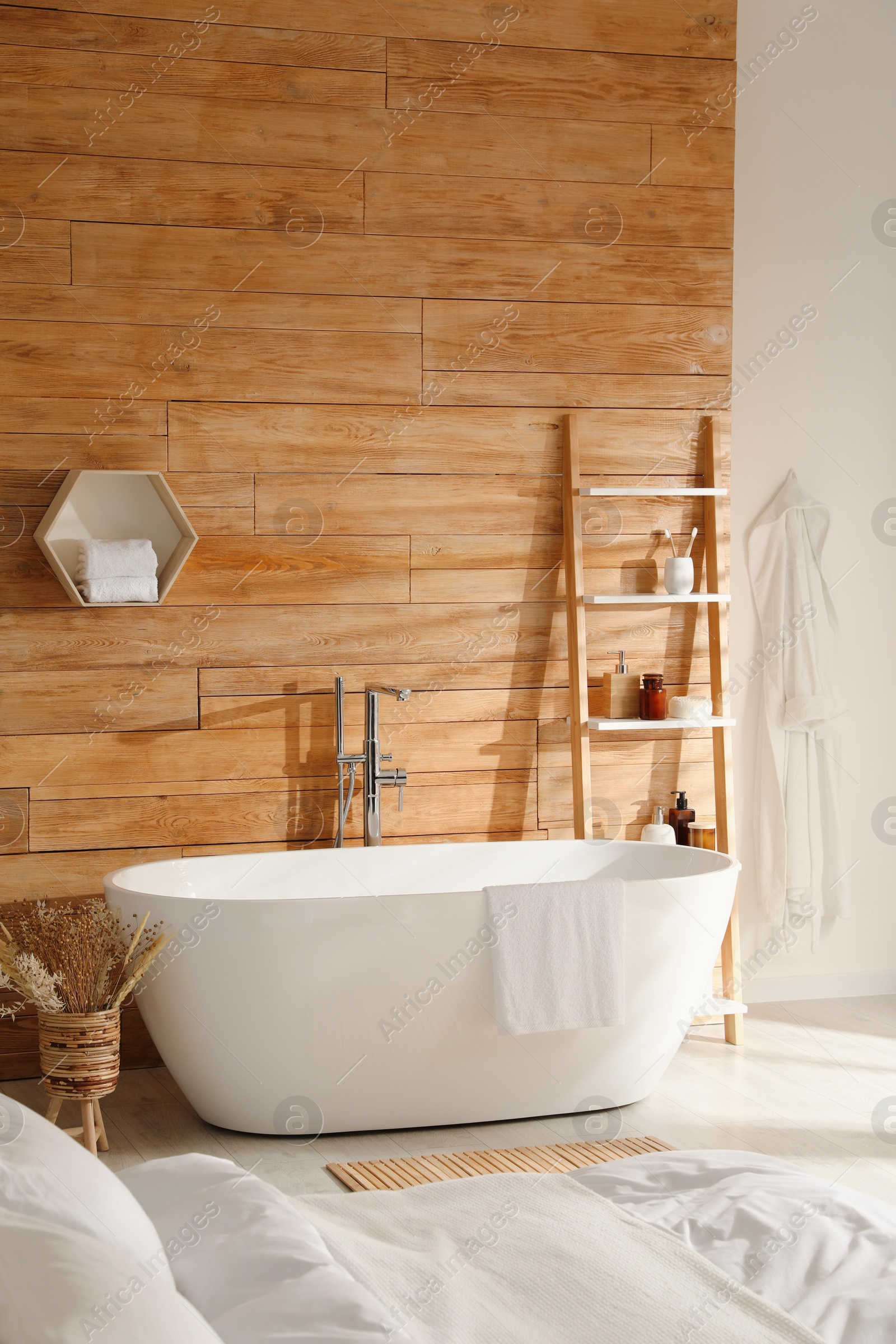 Photo of Stylish apartment interior with white bathtub and bed