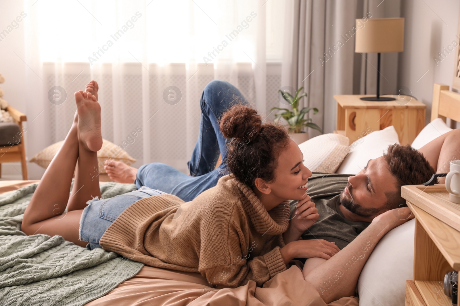 Photo of Lovely couple enjoying each other on bed at home