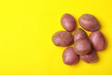 Pile of fresh organic potatoes and space for text on color background, top view