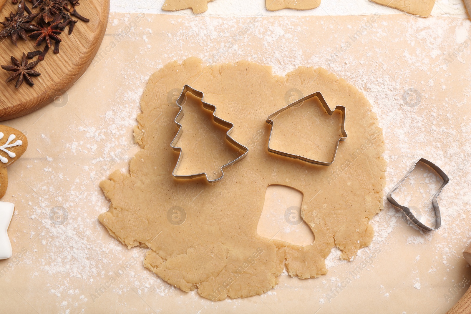 Photo of Making Christmas cookies. Raw dough, anise stars and cutters on white table, flat lay