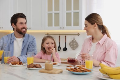 Photo of Happy family having breakfast at table in kitchen