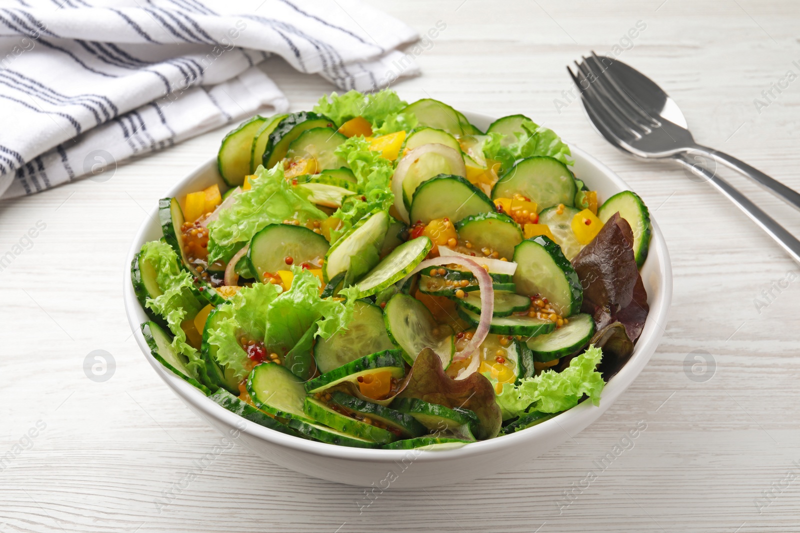 Photo of Delicious cucumber salad served on white wooden table