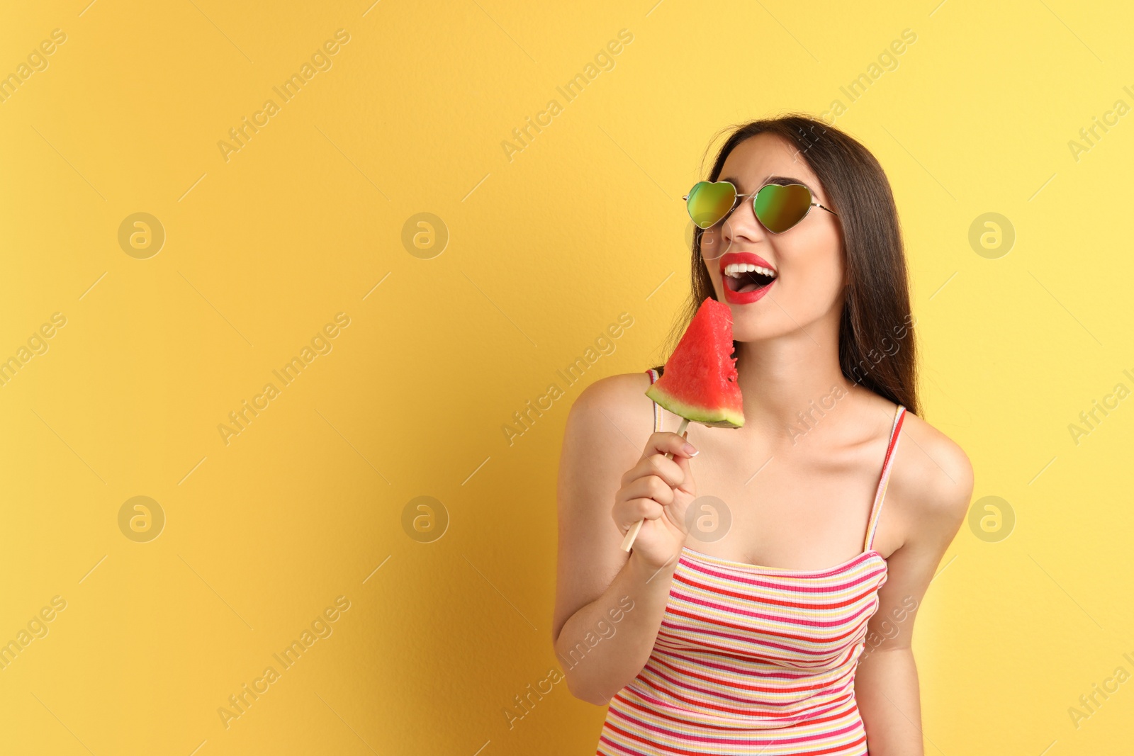 Photo of Beautiful young woman posing with watermelon on color background