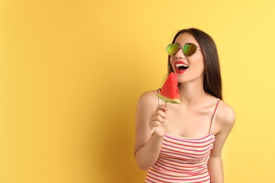 Photo of Beautiful young woman posing with watermelon on color background