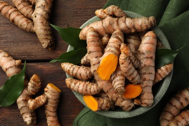 Fresh turmeric roots on wooden table, flat lay