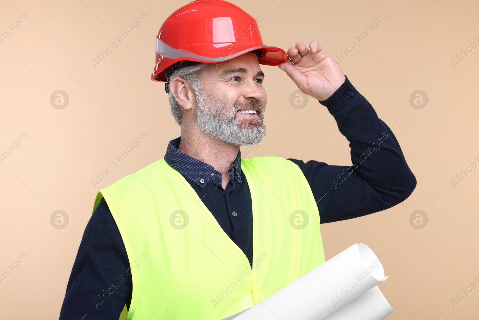 Photo of Architect in hard hat holding drafts on beige background