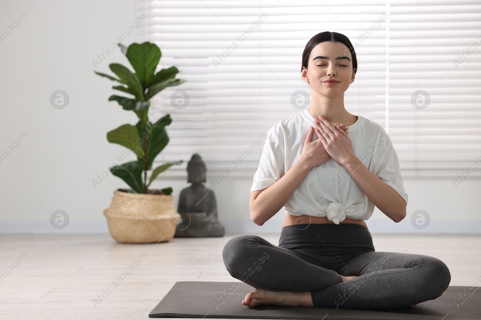 Photo of Beautiful girl meditating on mat in yoga studio