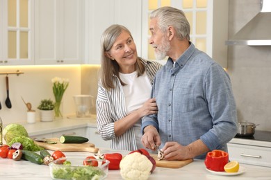 Photo of Happy senior couple cooking together in kitchen