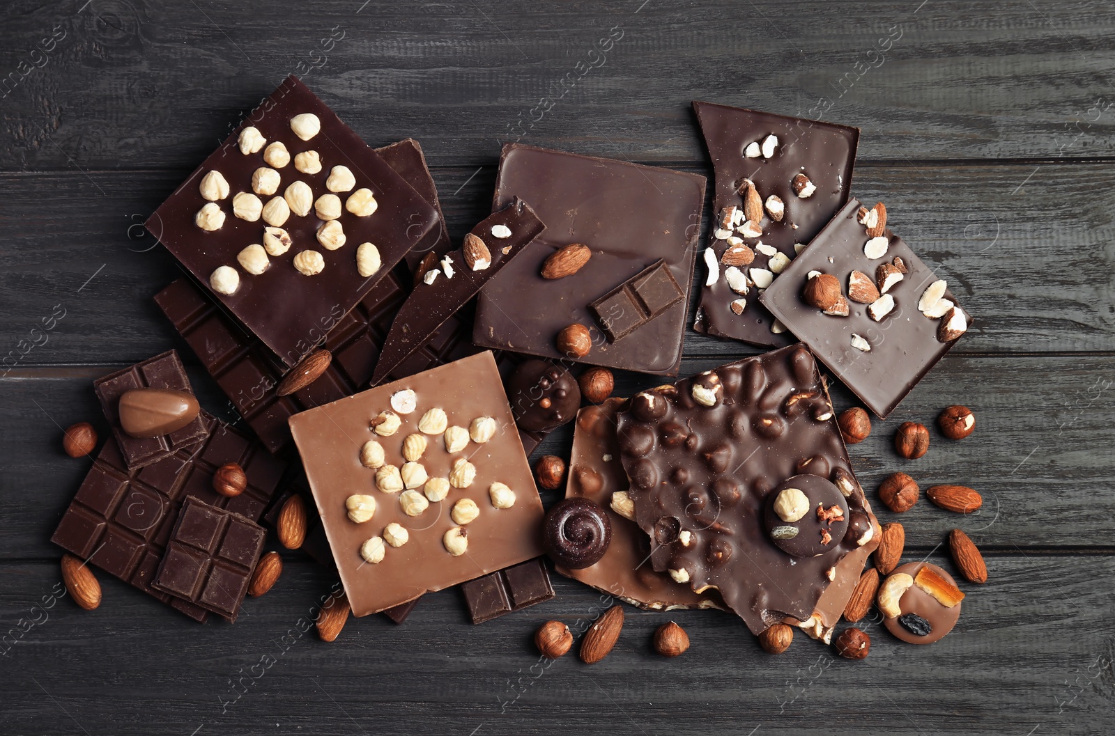 Photo of Different delicious chocolate bars and candies on wooden table, top view