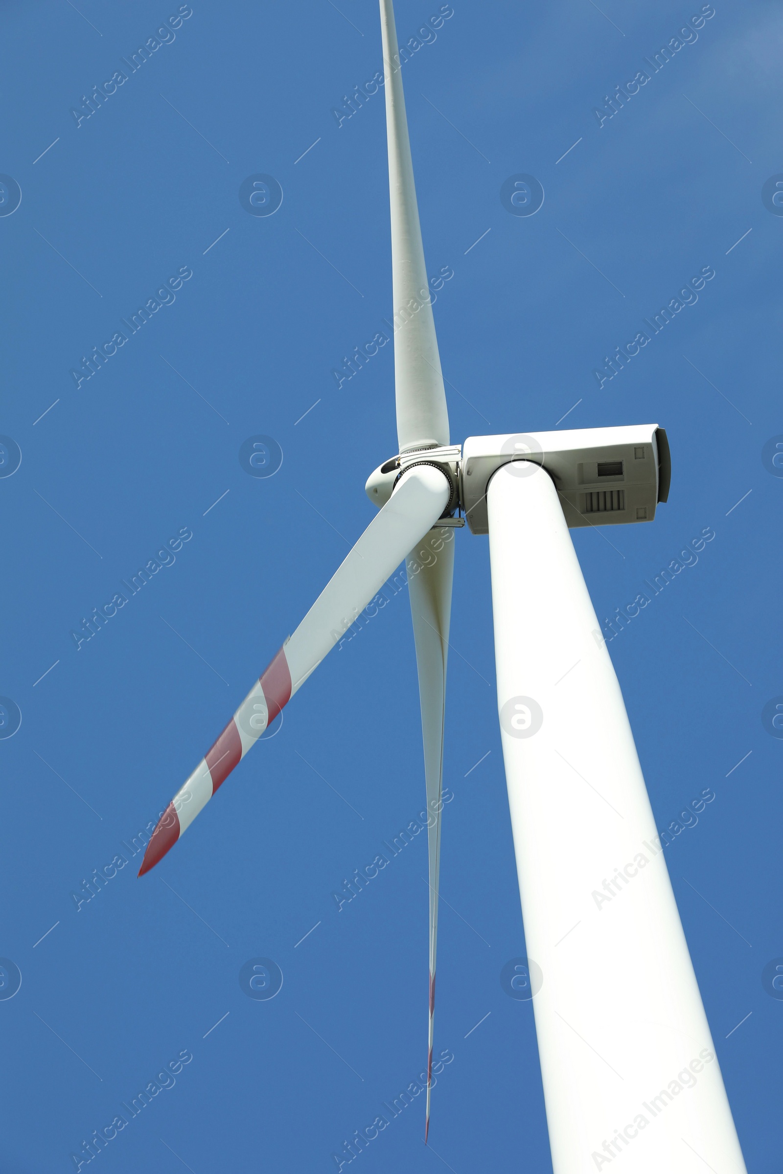 Photo of Modern wind turbine against blue sky, low angle view. Alternative energy source