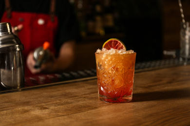 Photo of Glass of fresh alcoholic cocktail at bar counter. Space for text