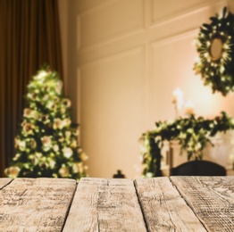 Image of Empty wooden surface and blurred view of Christmas tree in room, space for text. Interior design