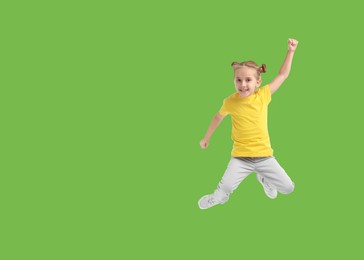 Image of Cute girl jumping on light green background, space for text