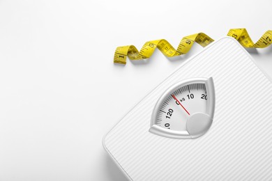 Scales and measuring tape on white background, top view. Space for text