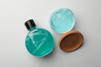Photo of Jar and bottle with blue cosmetic gel on white background, flat lay
