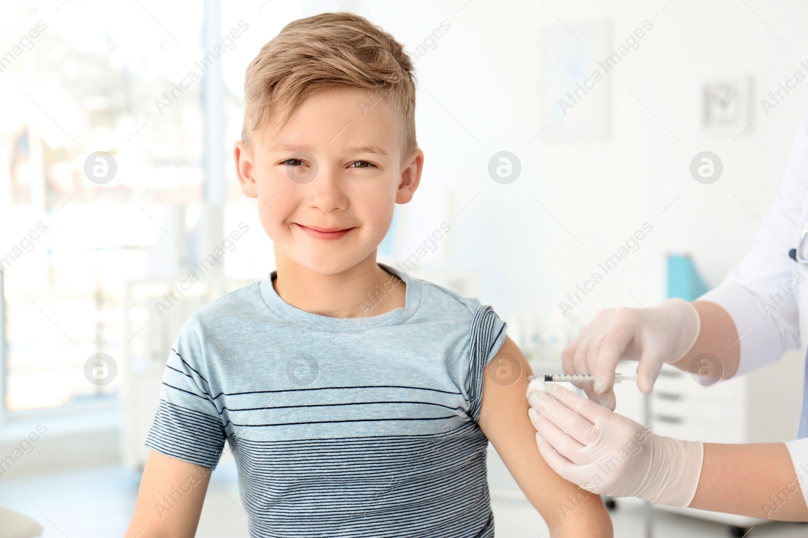 Photo of Doctor vaccinating little boy in hospital