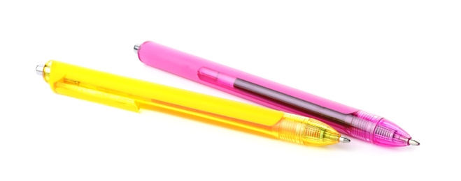 Photo of Pink and yellow retractable pens isolated on white