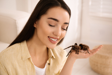 Woman holding striped knee tarantula at home. Exotic pet