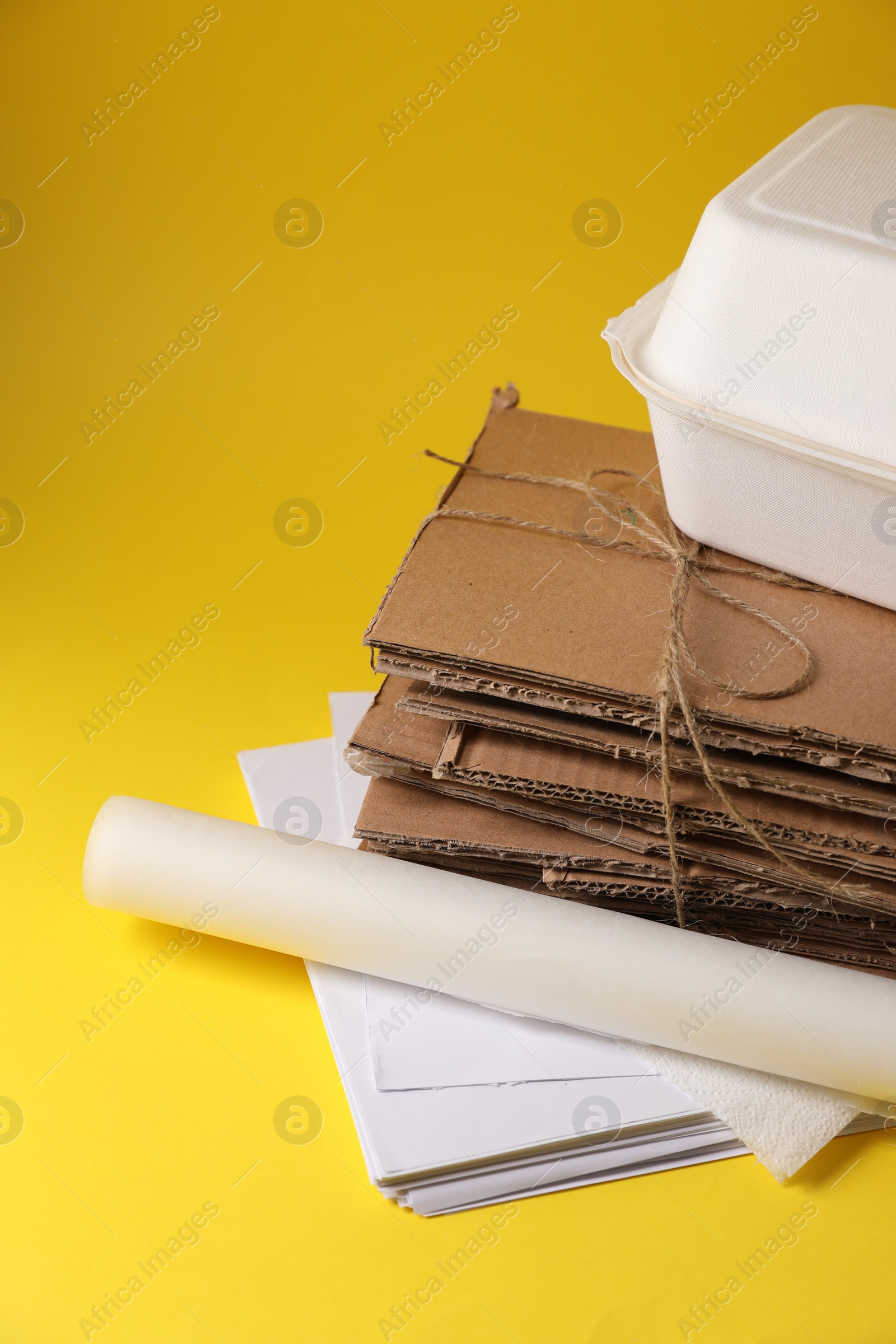 Photo of Heap of waste paper on yellow background