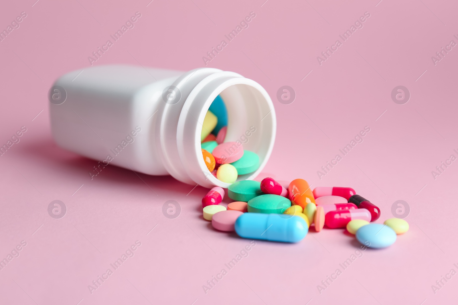 Photo of Bottle with pills on color background