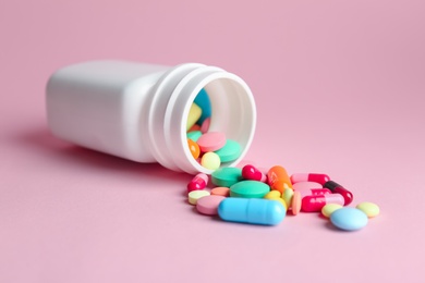 Photo of Bottle with pills on color background