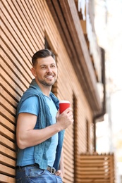 Photo of Portrait of young man with cup of coffee outdoors