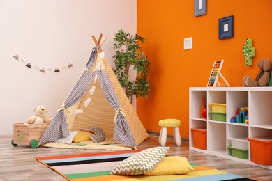 Cozy kids room interior with play tent and toys